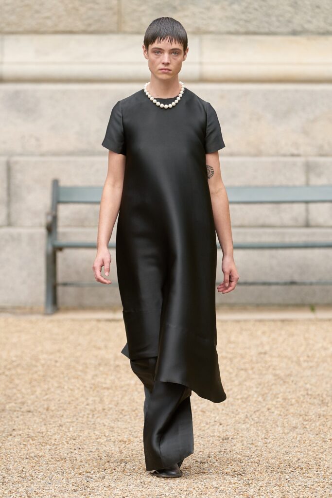 A relaxed black silk dress with short sleeves and an asymmetric design.