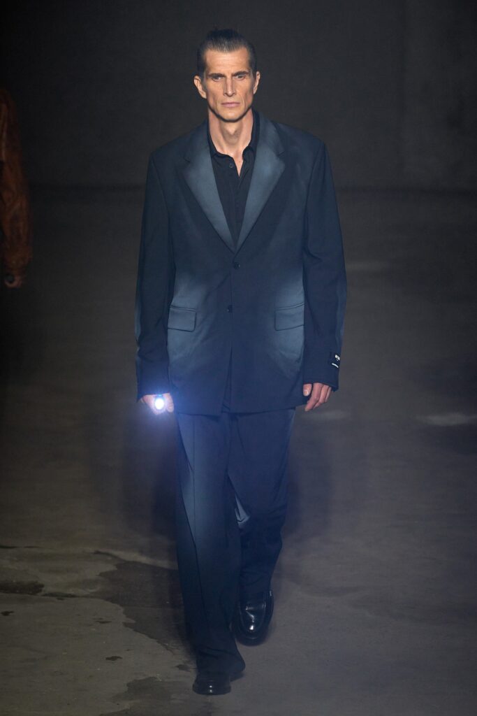 A tailored black silk suit with long sleeves and a collared shirt.