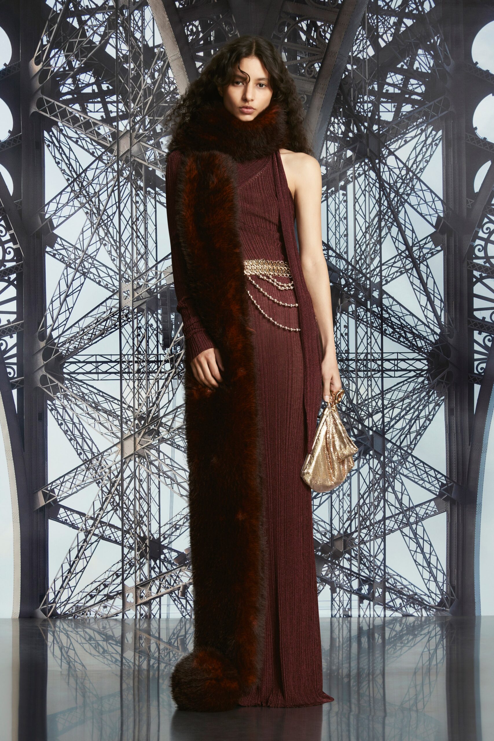 A fitted burgundy knit dress with a high neckline and asymmetric design featuring fur detailing.