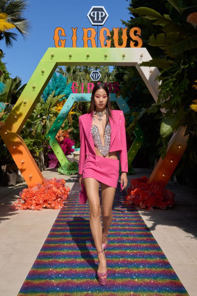 A fitted pink satin blazer with a V-neckline and an asymmetric sequined skirt.