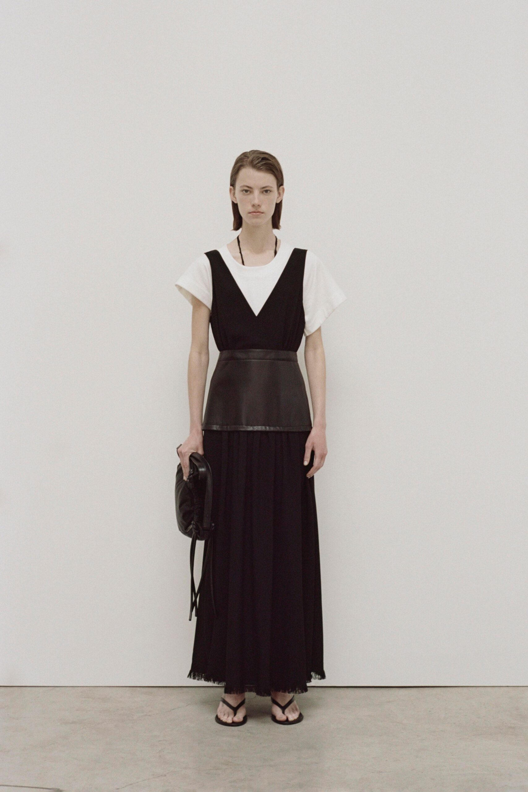 A fitted black and white layered dress with a V-neckline and short sleeves.