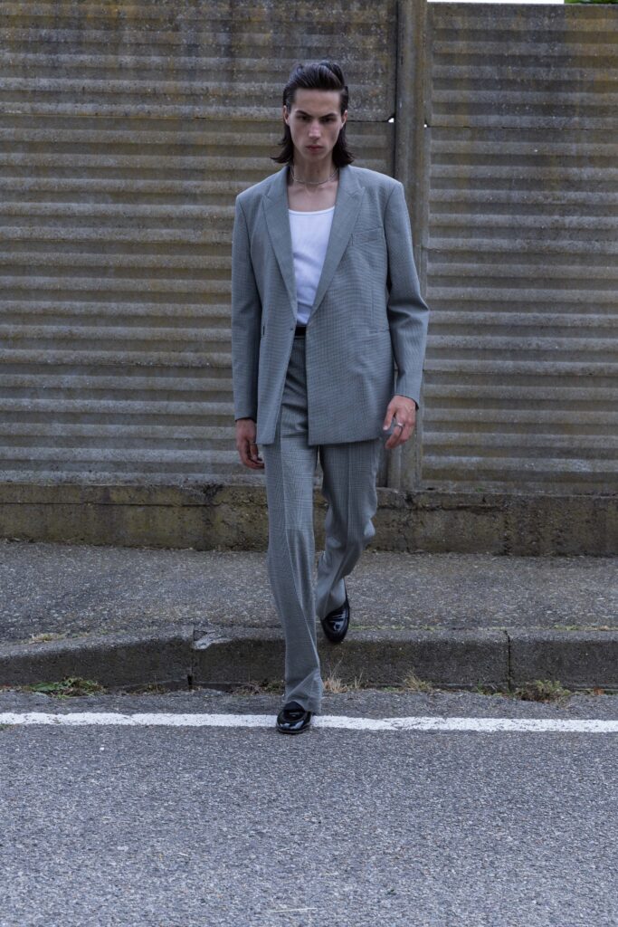 A tailored gray suit featuring a long-sleeve collared shirt and straight-leg trousers.