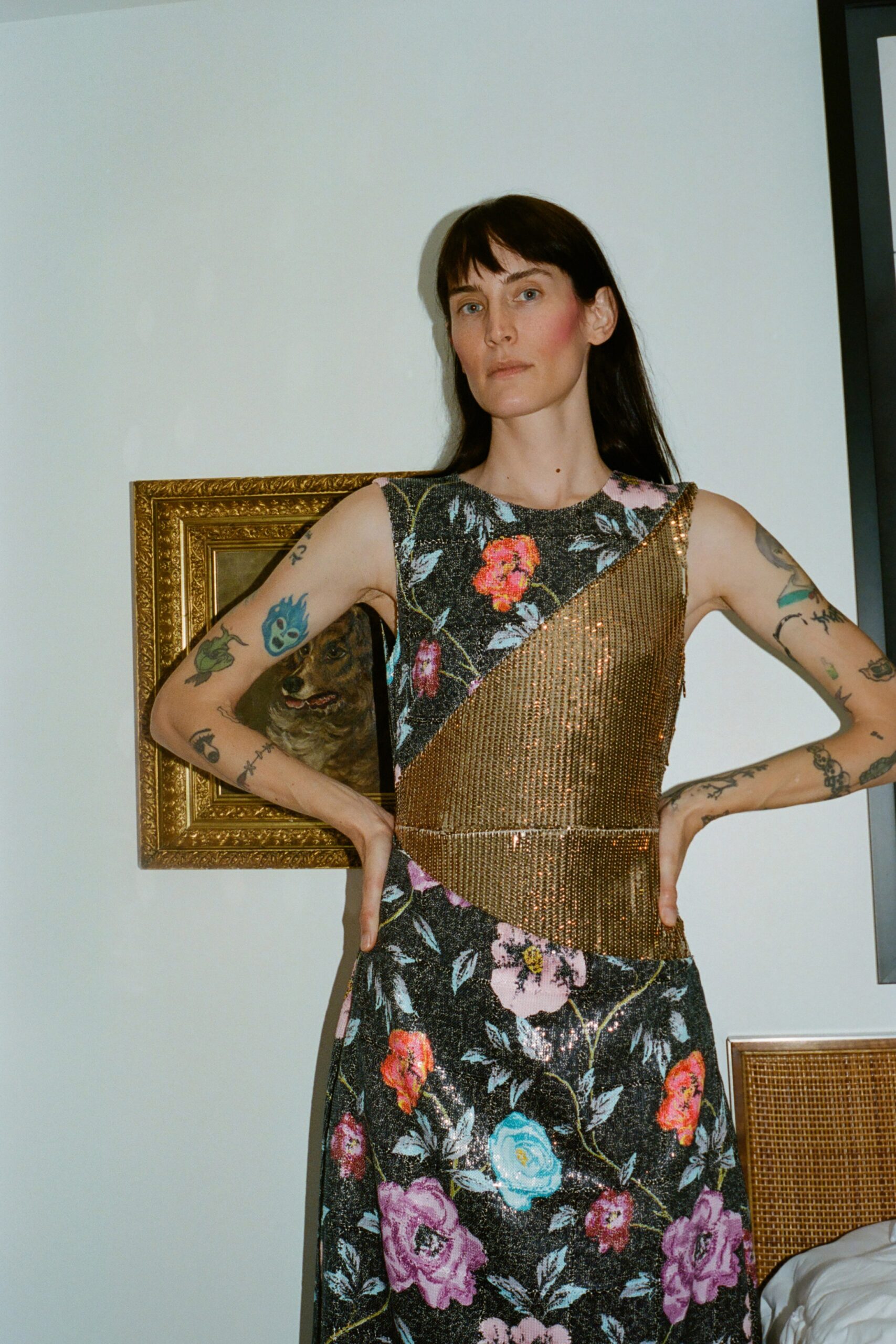 A fitted black dress with floral patterns and an asymmetric design, featuring a high neckline.