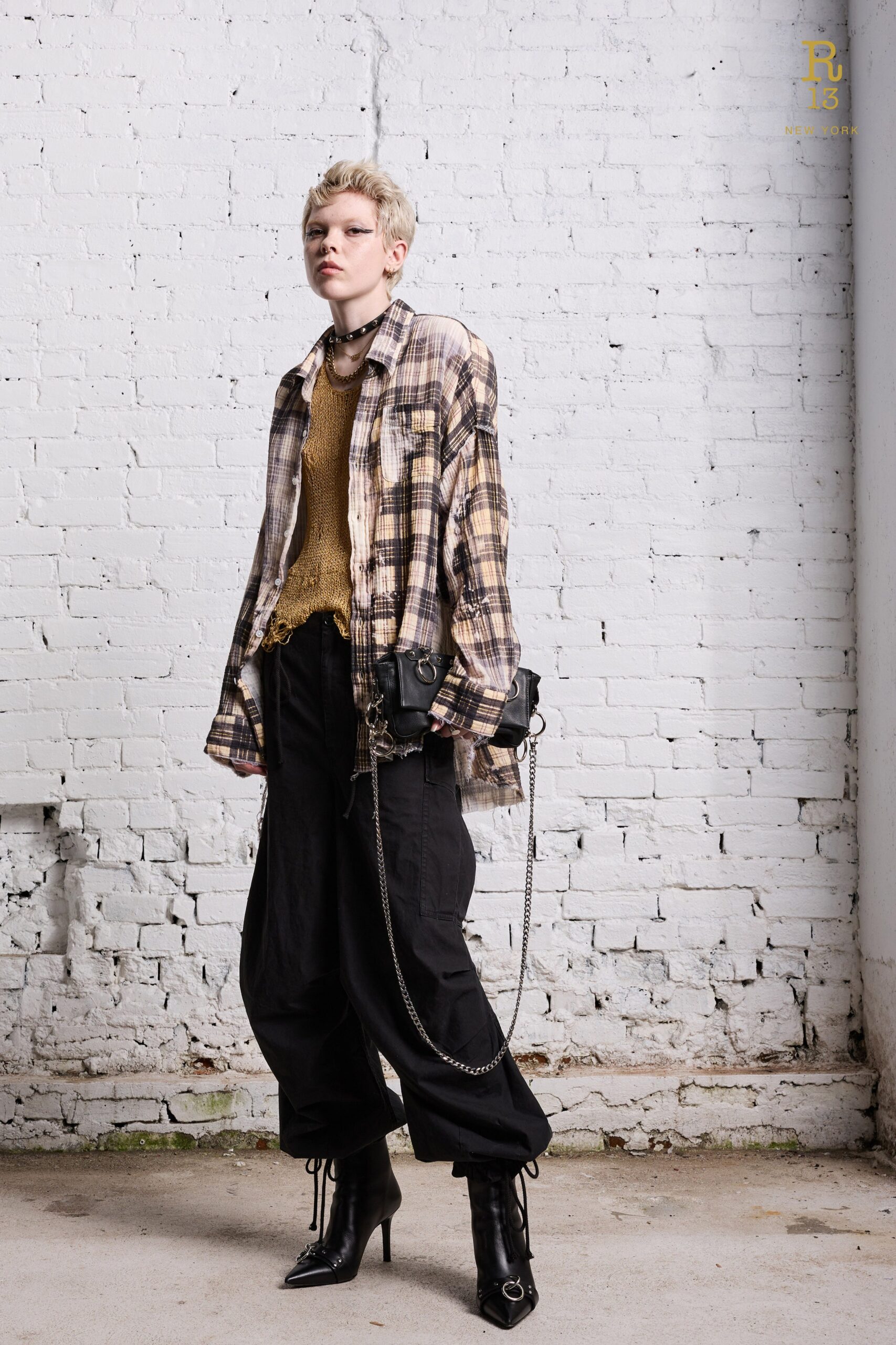 A relaxed beige checked shirt paired with black pants, creating a stylish casual look.