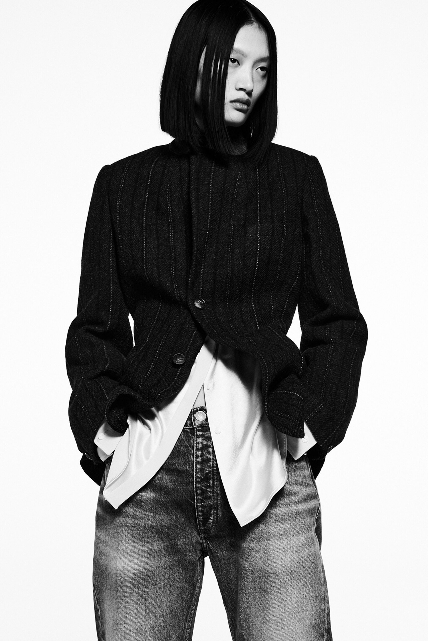 A relaxed black striped jacket layered over a white collared shirt, perfect for a chic look.
