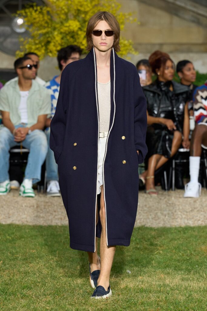 An oversized blue coat with long sleeves and a collared design featuring button details.