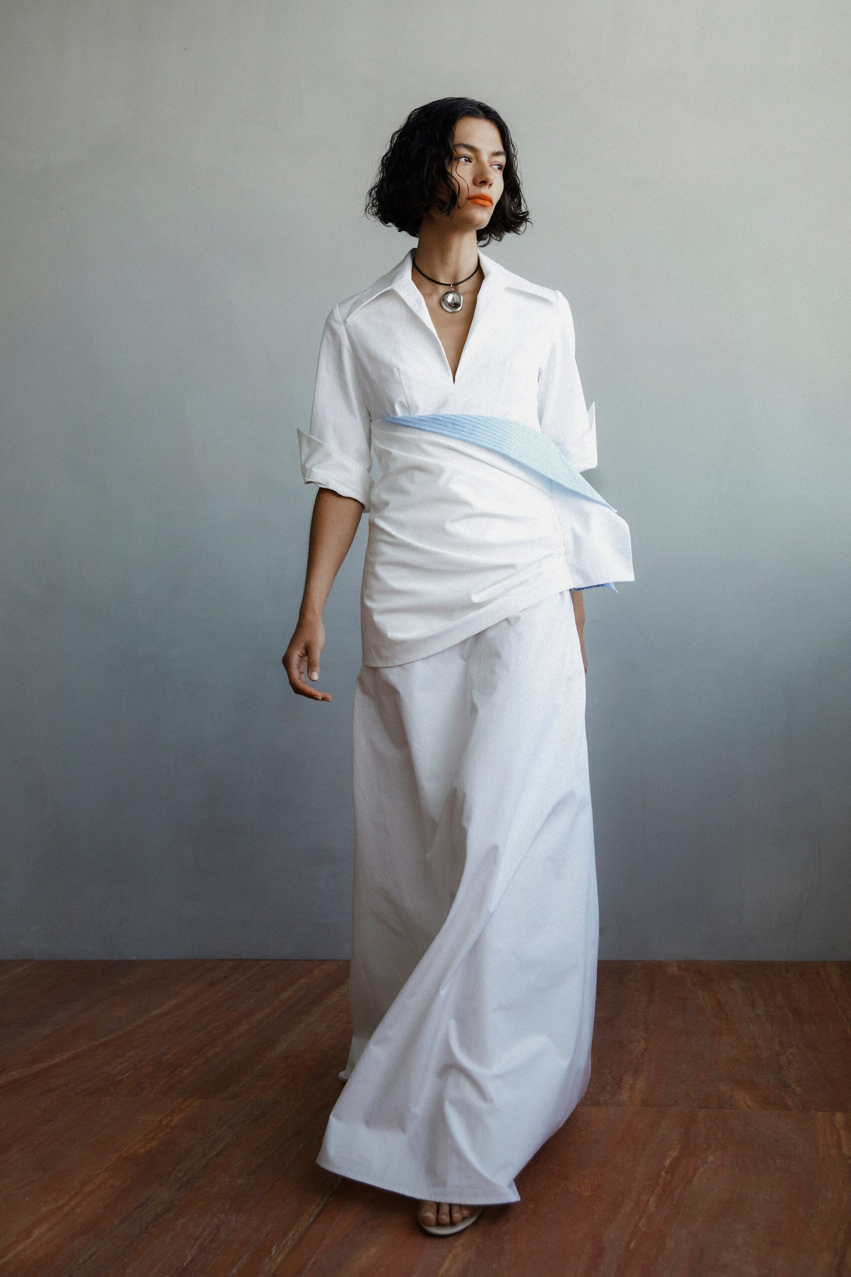 A relaxed white shirt with a collar and long sleeves paired with wide-leg pants.