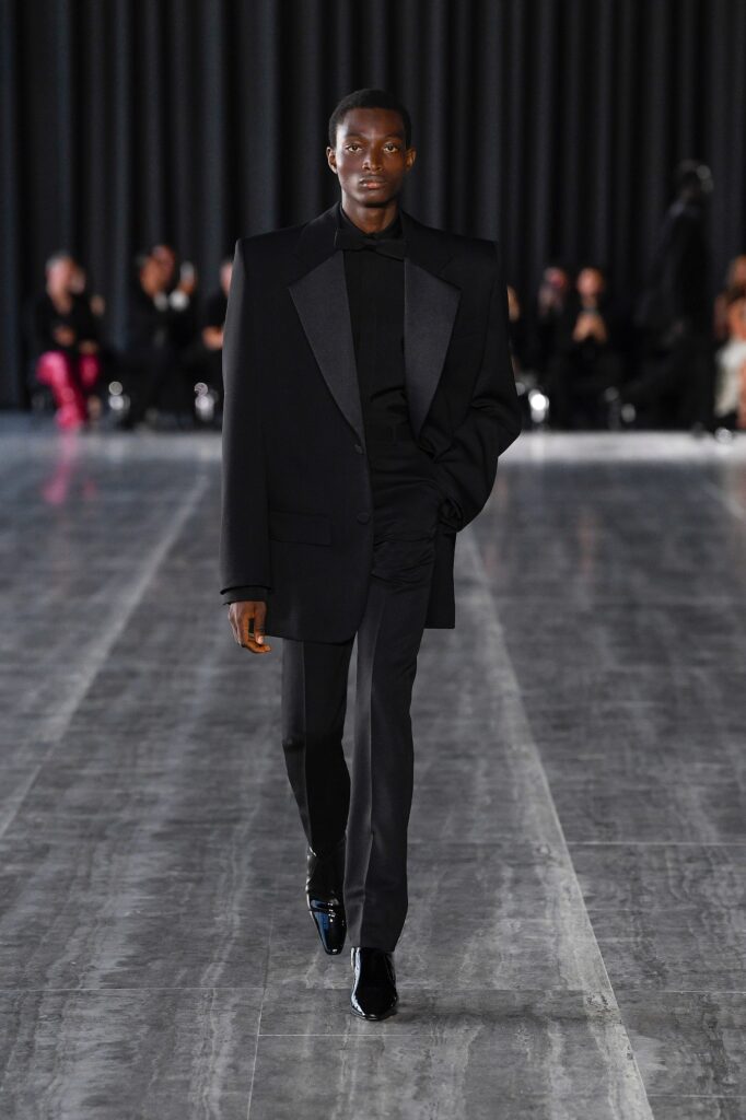 A tailored black wool suit with a structured design and long sleeves.