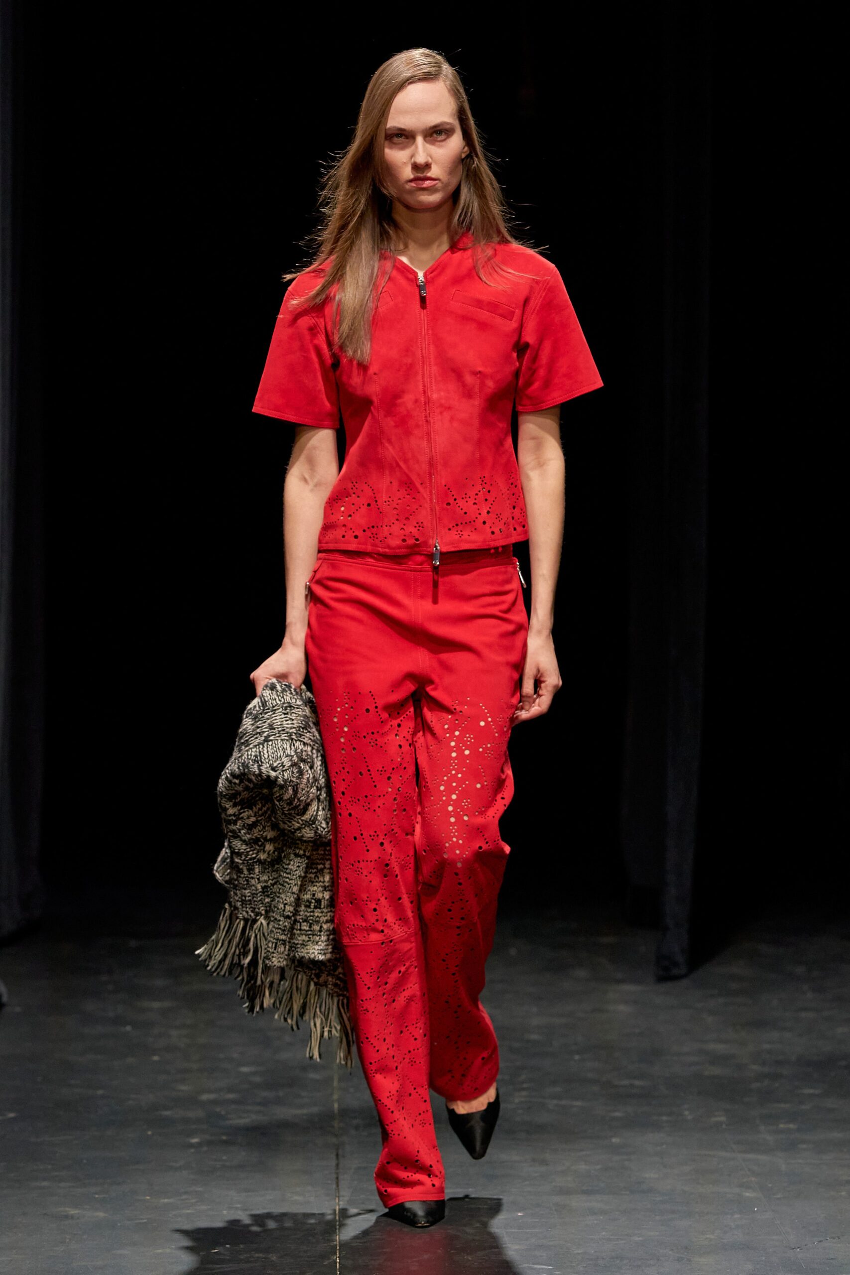 A fitted red jacket with short sleeves and embroidered details, paired with matching pants.