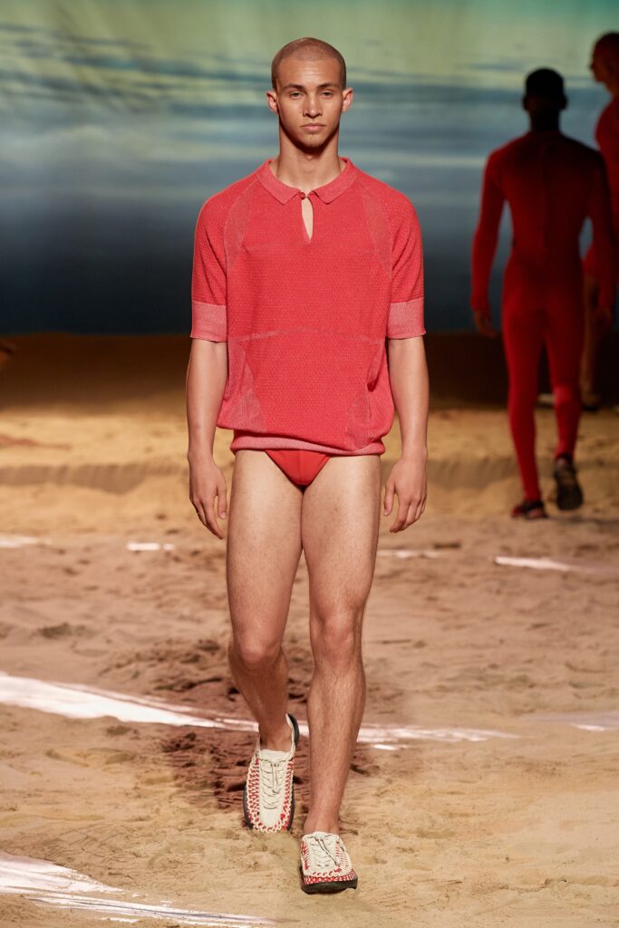 A fitted red mesh short-sleeve top with a cutout detail, paired with a swimsuit bottom.
