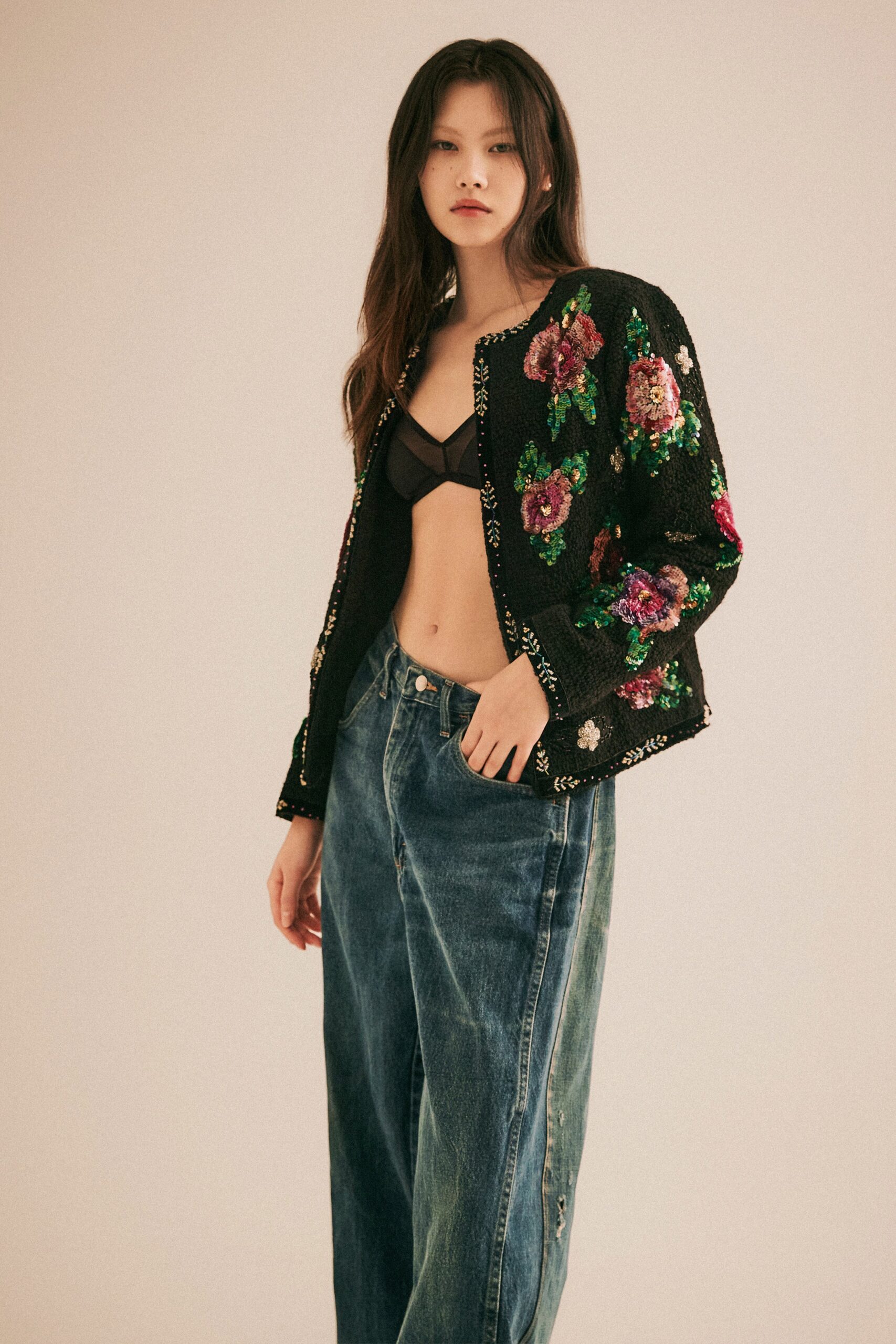 A relaxed black sequined jacket paired with a casual blue denim top.