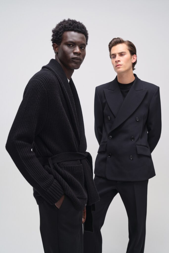 A relaxed black wool jacket with long sleeves and a collared design, paired with matching pants.