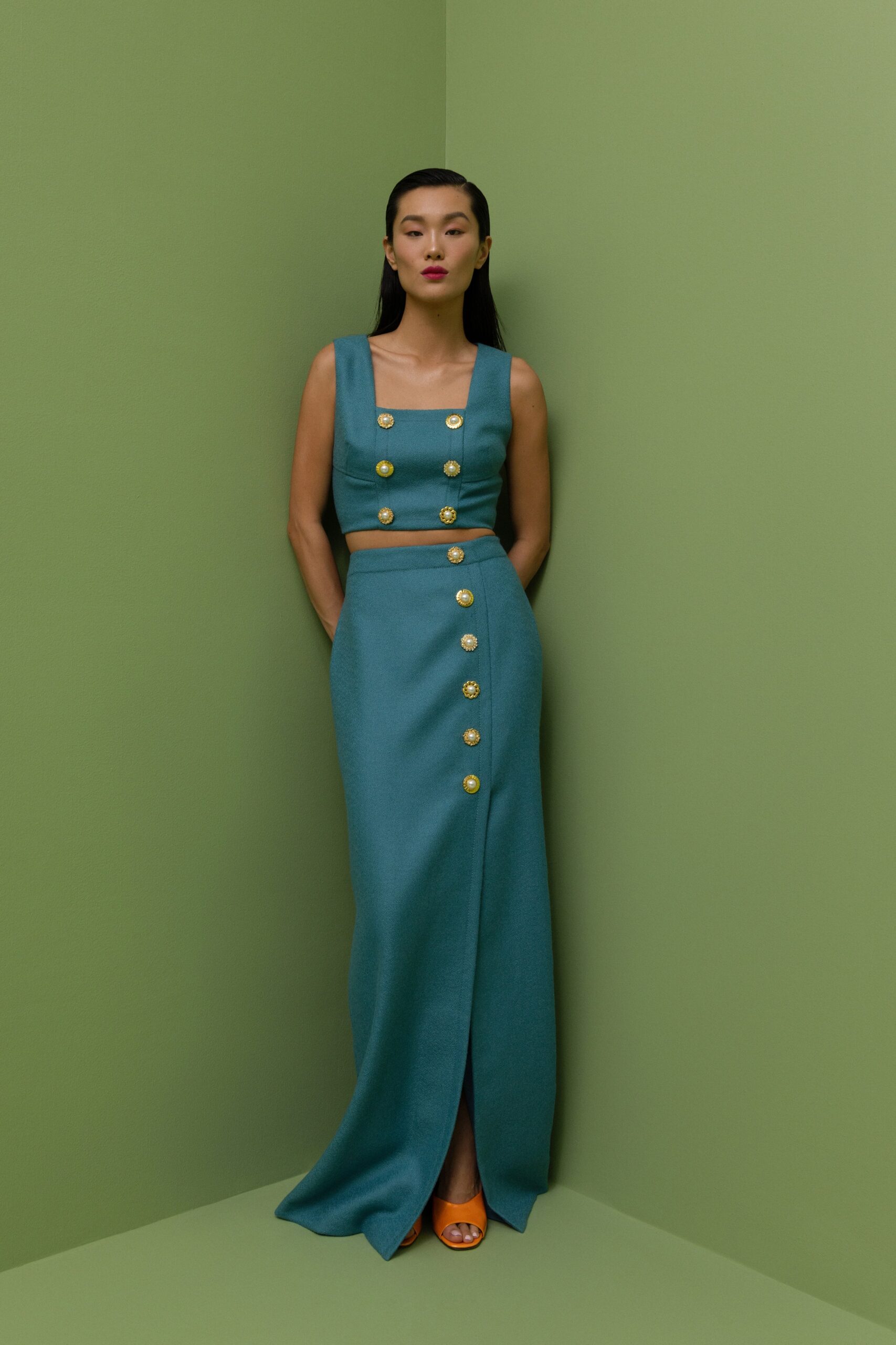 A fitted blue wool dress with a sleeveless design and a high slit.
