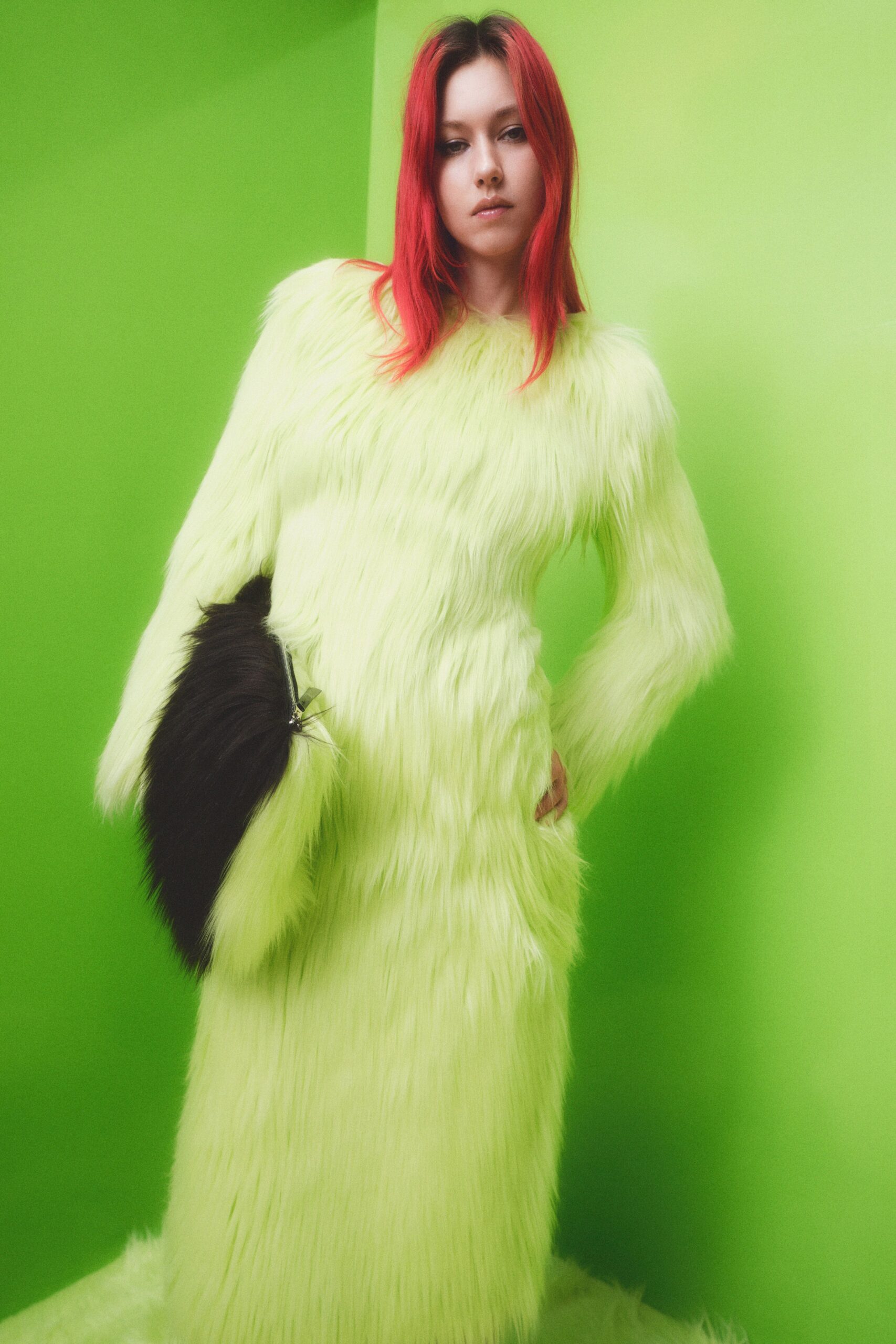 A fitted green fur dress with long sleeves and a high neckline.