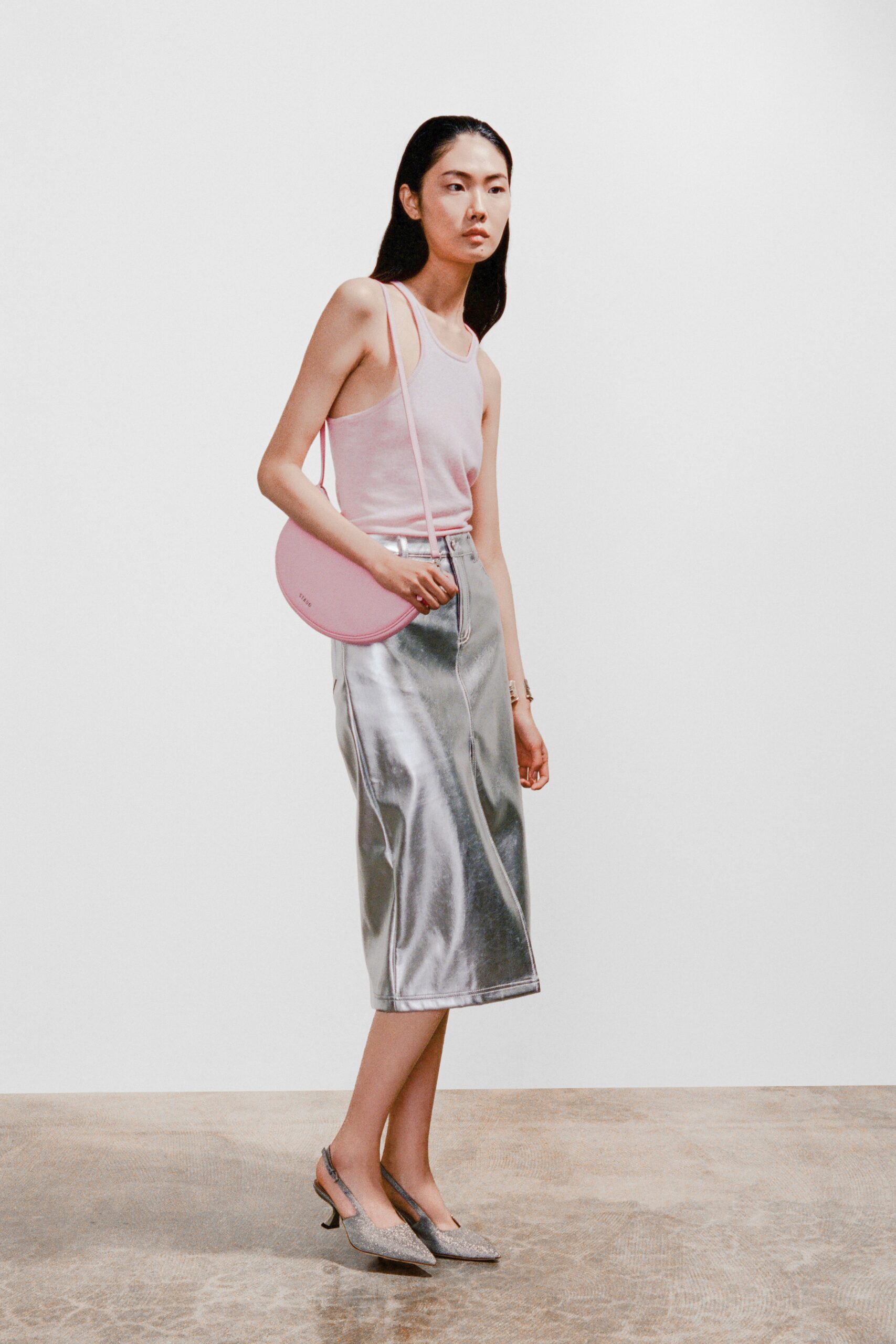 A fitted pink sleeveless top paired with a high-waisted silver metallic skirt.