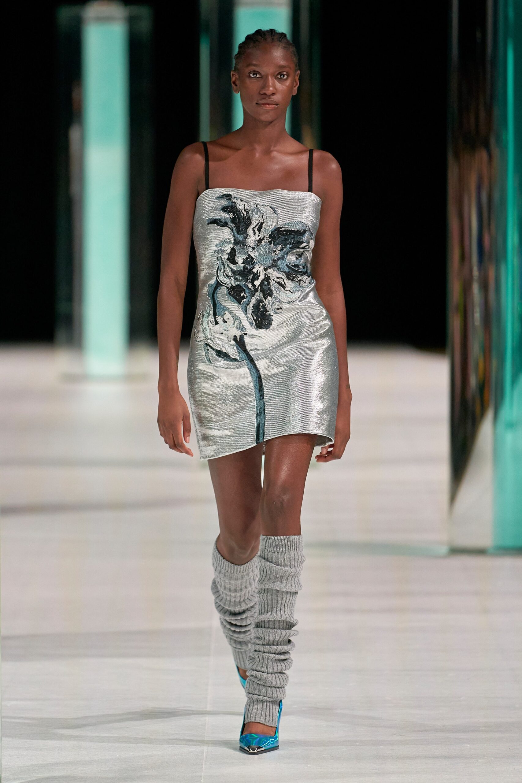 A fitted silver sleeveless dress with a V-neckline and printed design.