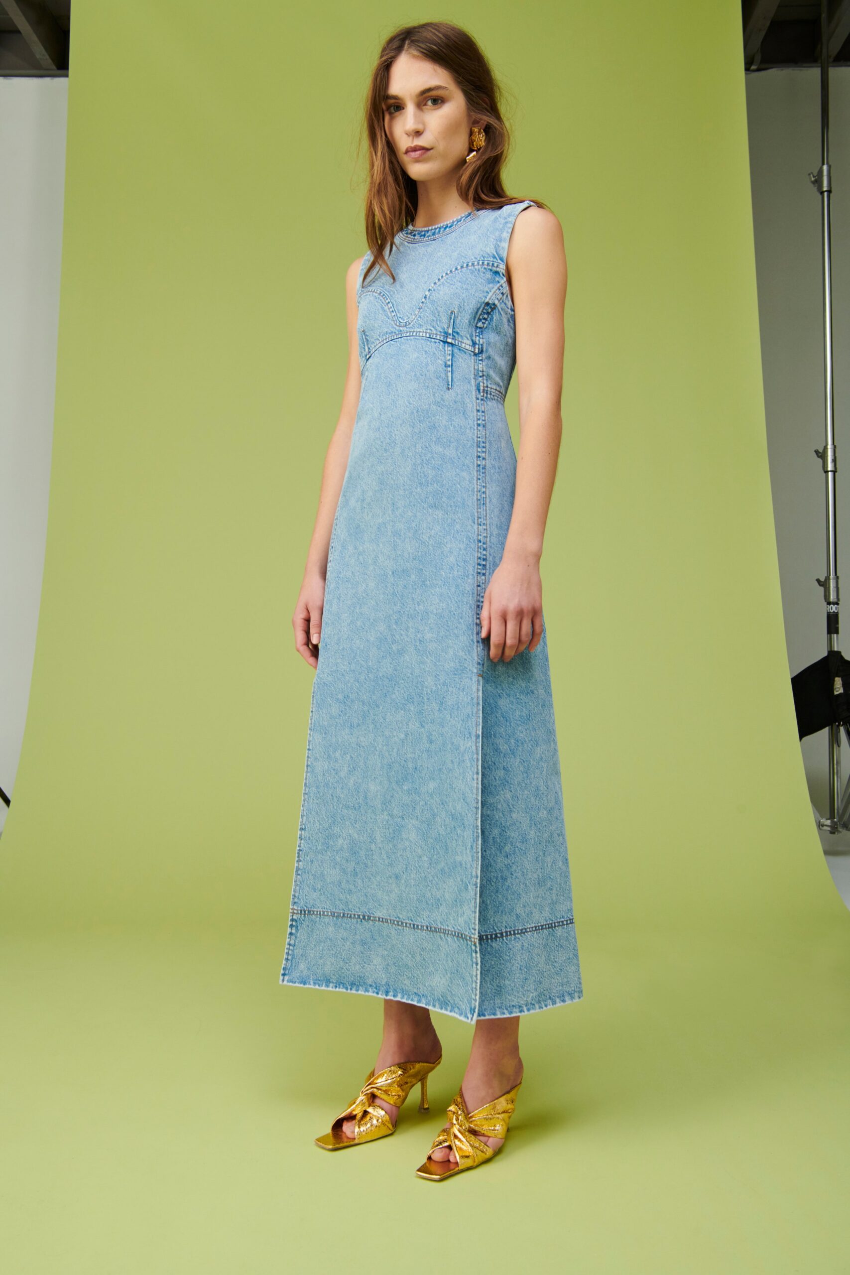 A fitted blue denim dress with a sleeveless design and a maxi silhouette.