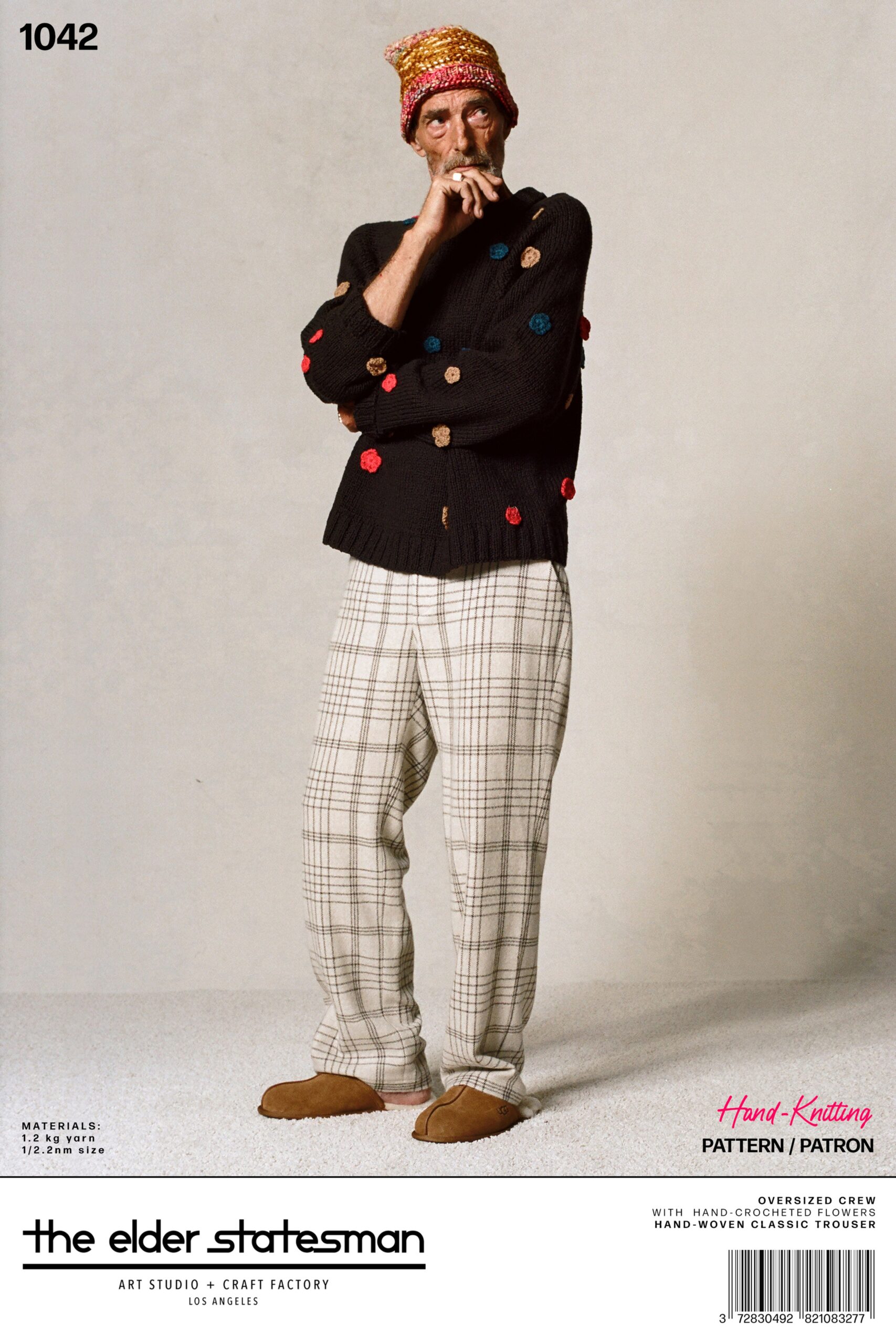 A relaxed black long-sleeve sweater with a collar paired with beige checked pants.