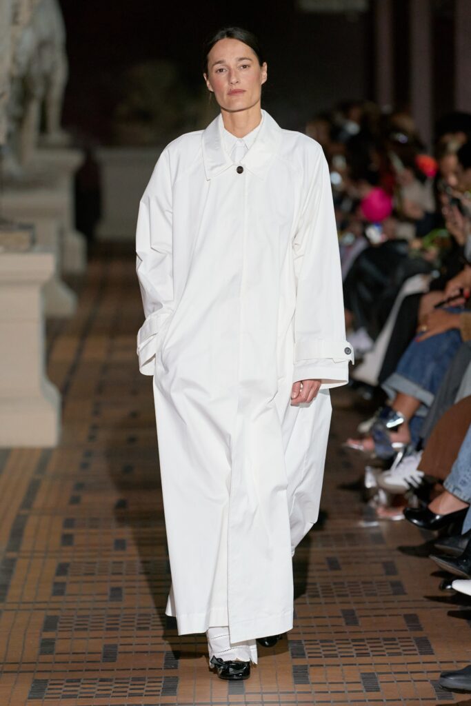 An oversized white cotton coat with long sleeves and a collared design.