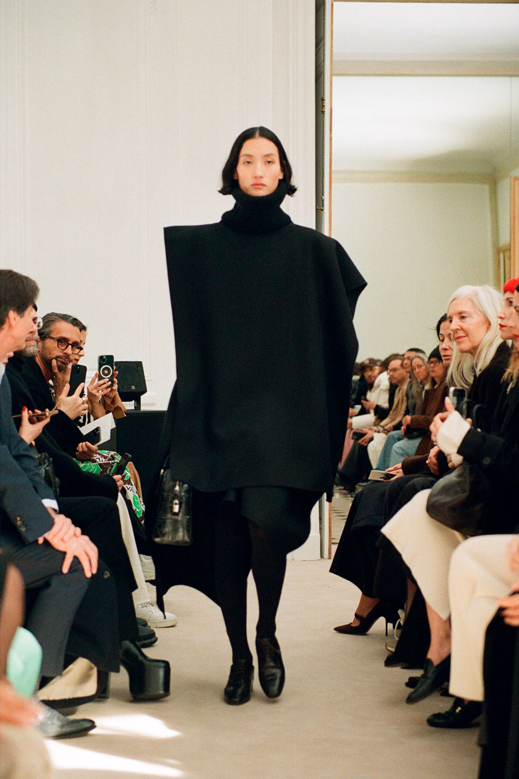 An oversized black wool dress with a high neckline and asymmetric design.