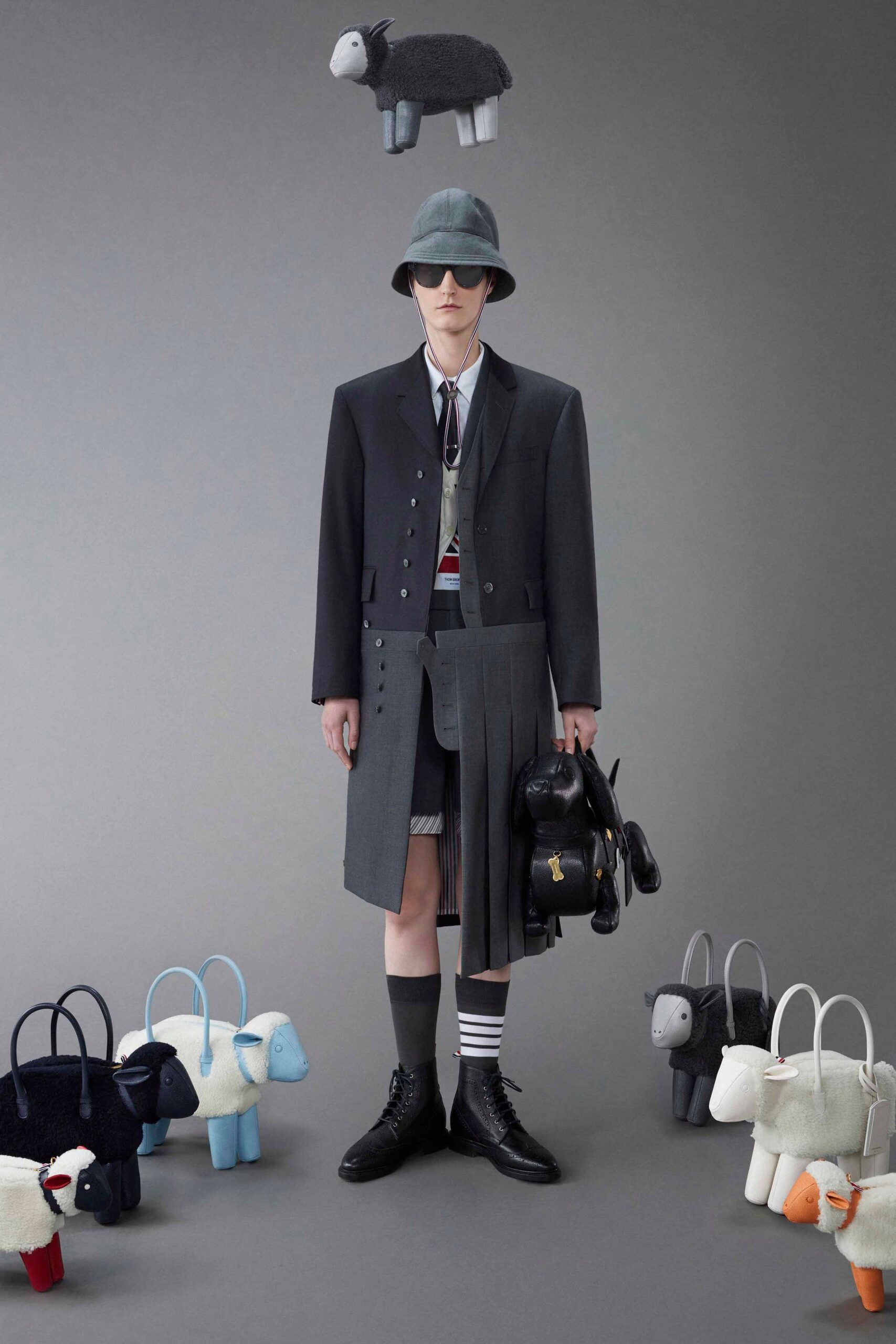 A structured black wool coat layered over a vest with pleated detailing.