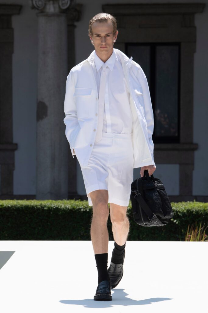 A fitted white jacket paired with matching shorts, featuring a collared design and buttoned details.