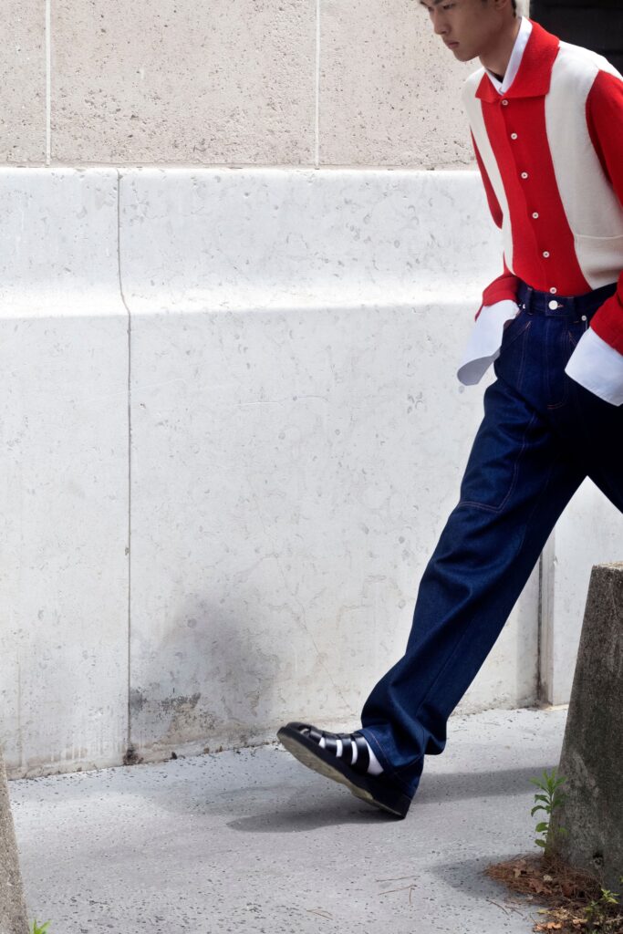 A relaxed-fit red and white long-sleeve collared shirt paired with wide-leg blue pants.