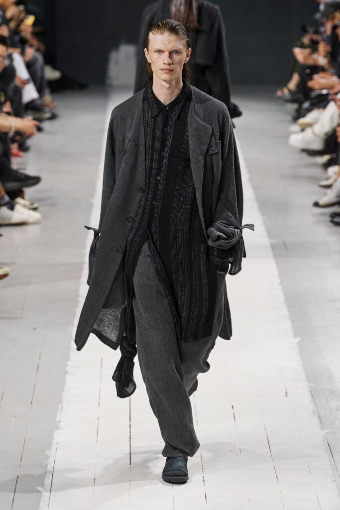A relaxed black coat with long sleeves and collared shirt paired with matching pants.