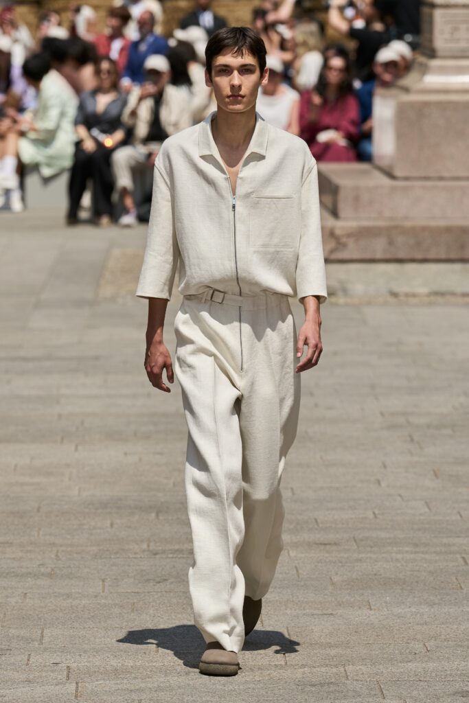 A relaxed beige linen shirt with long sleeves and collared design paired with straight-leg pants.