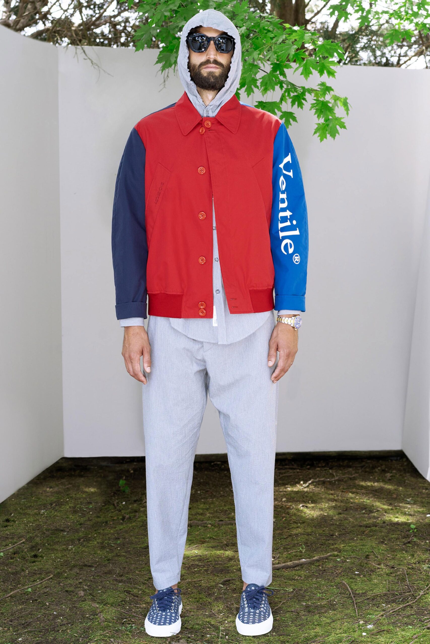 A relaxed-fit red and blue long-sleeve jacket paired with gray pants.