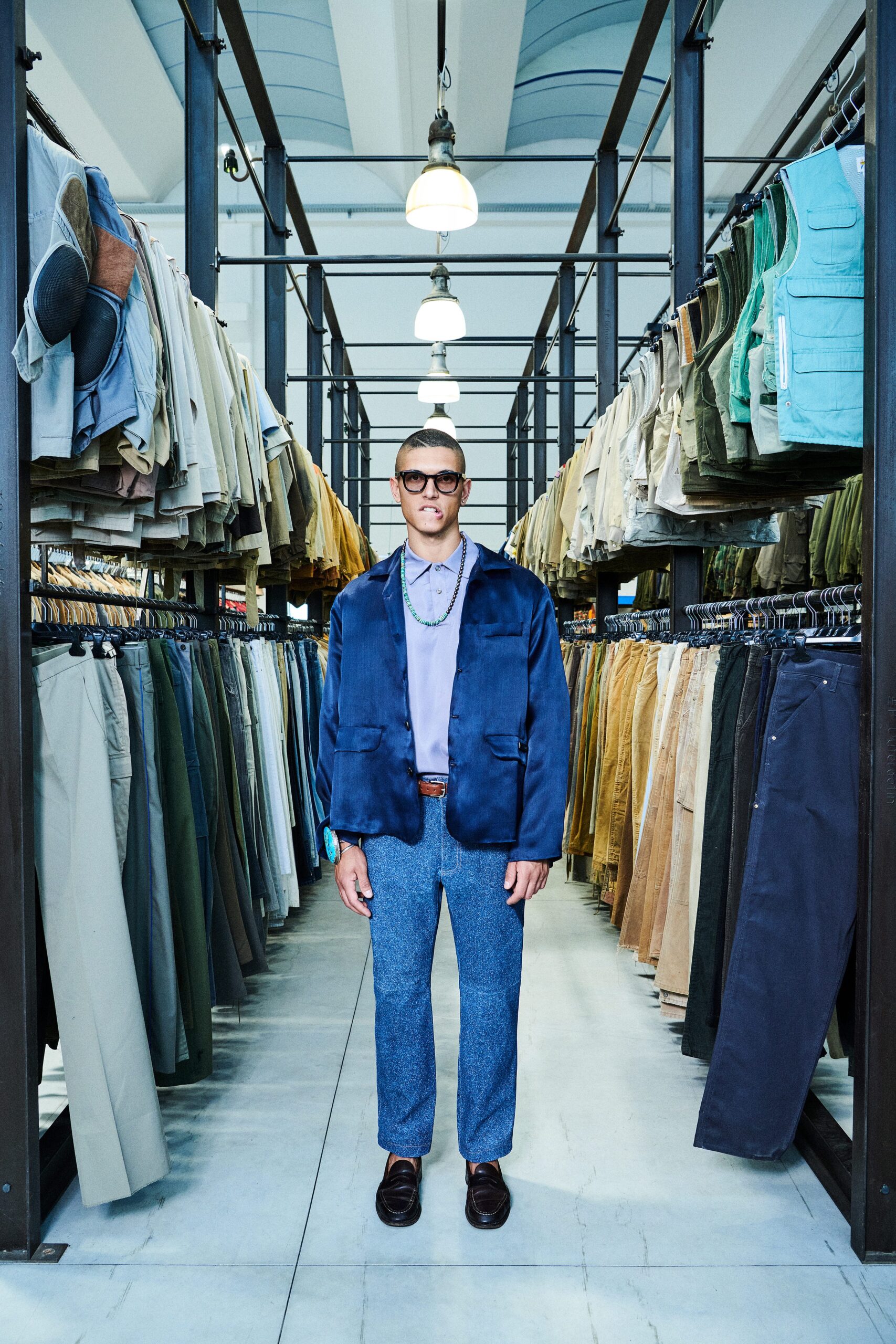 A relaxed blue jacket with long sleeves and a collared neckline paired with straight-leg gray pants.