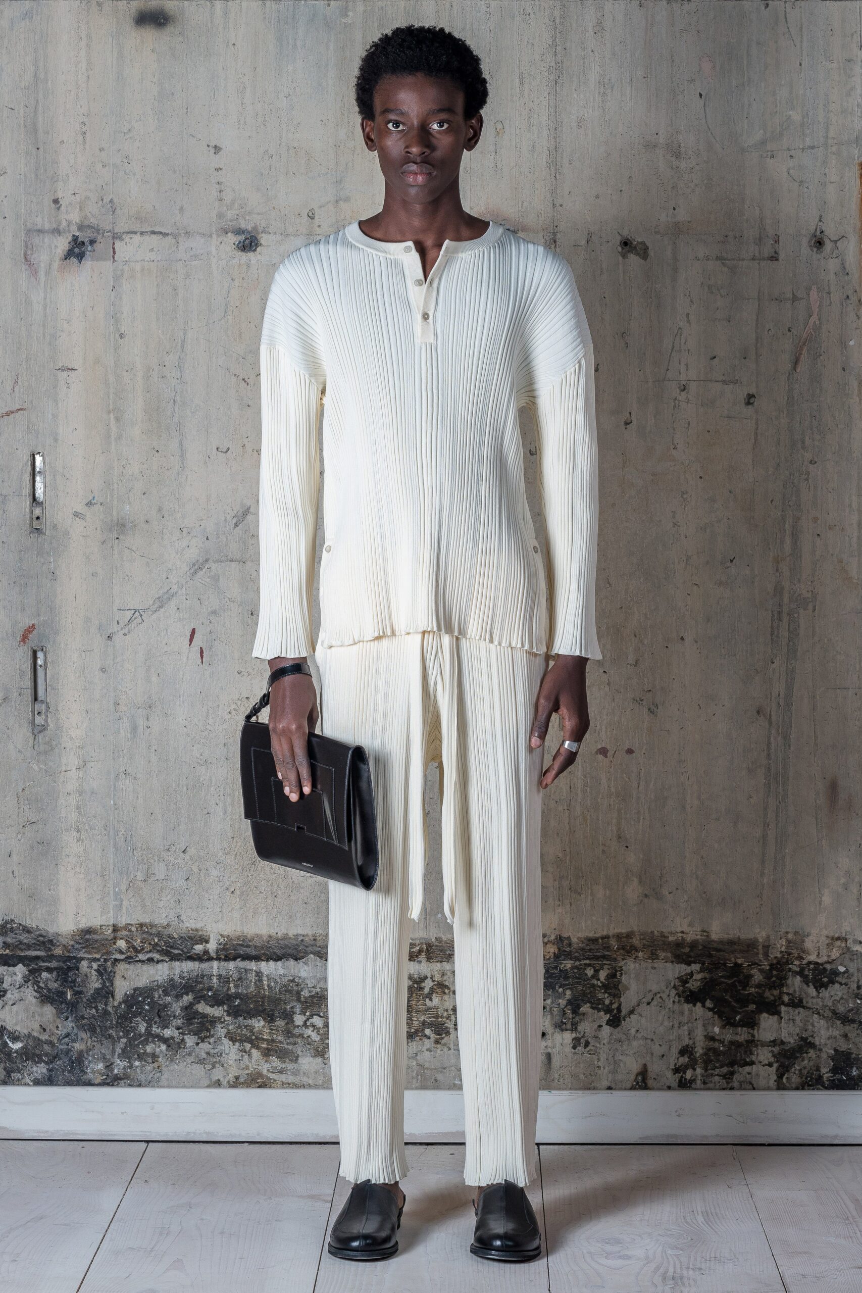 A relaxed white pleated long-sleeve shirt paired with matching pants for a modern look.