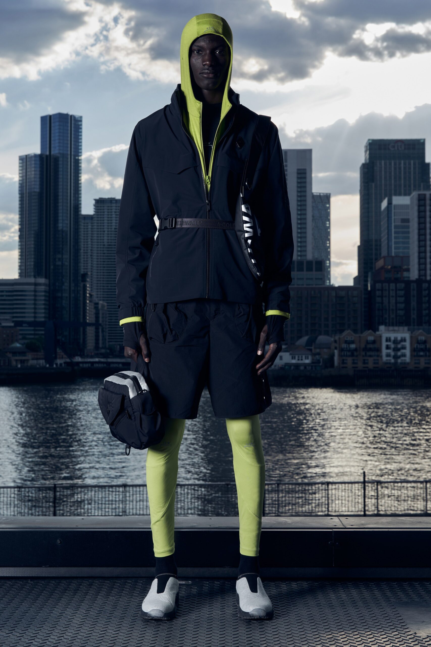 A fitted black jacket with a hood paired with neon green shorts for a sporty look.
