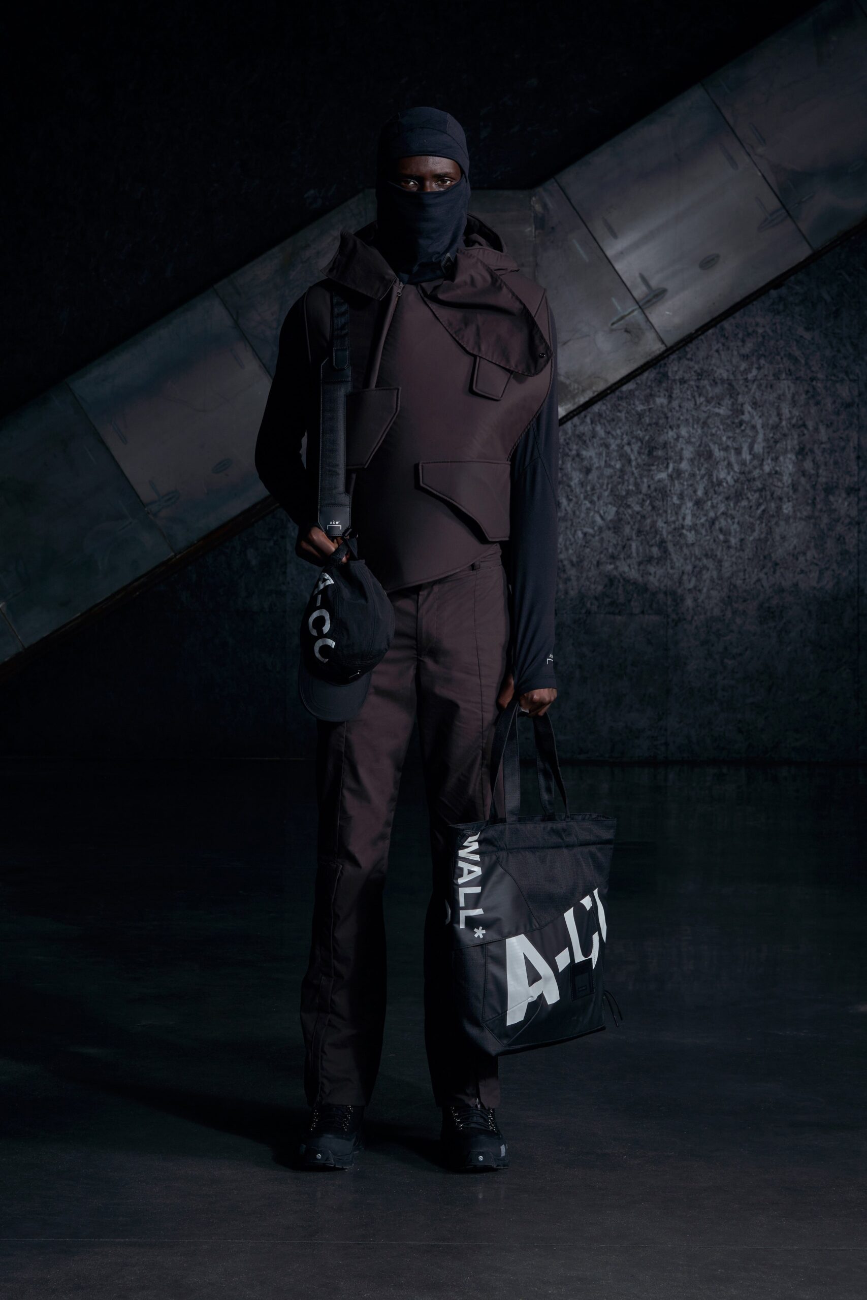 A fitted black cotton jacket with long sleeves and matching pants featuring zippered details.