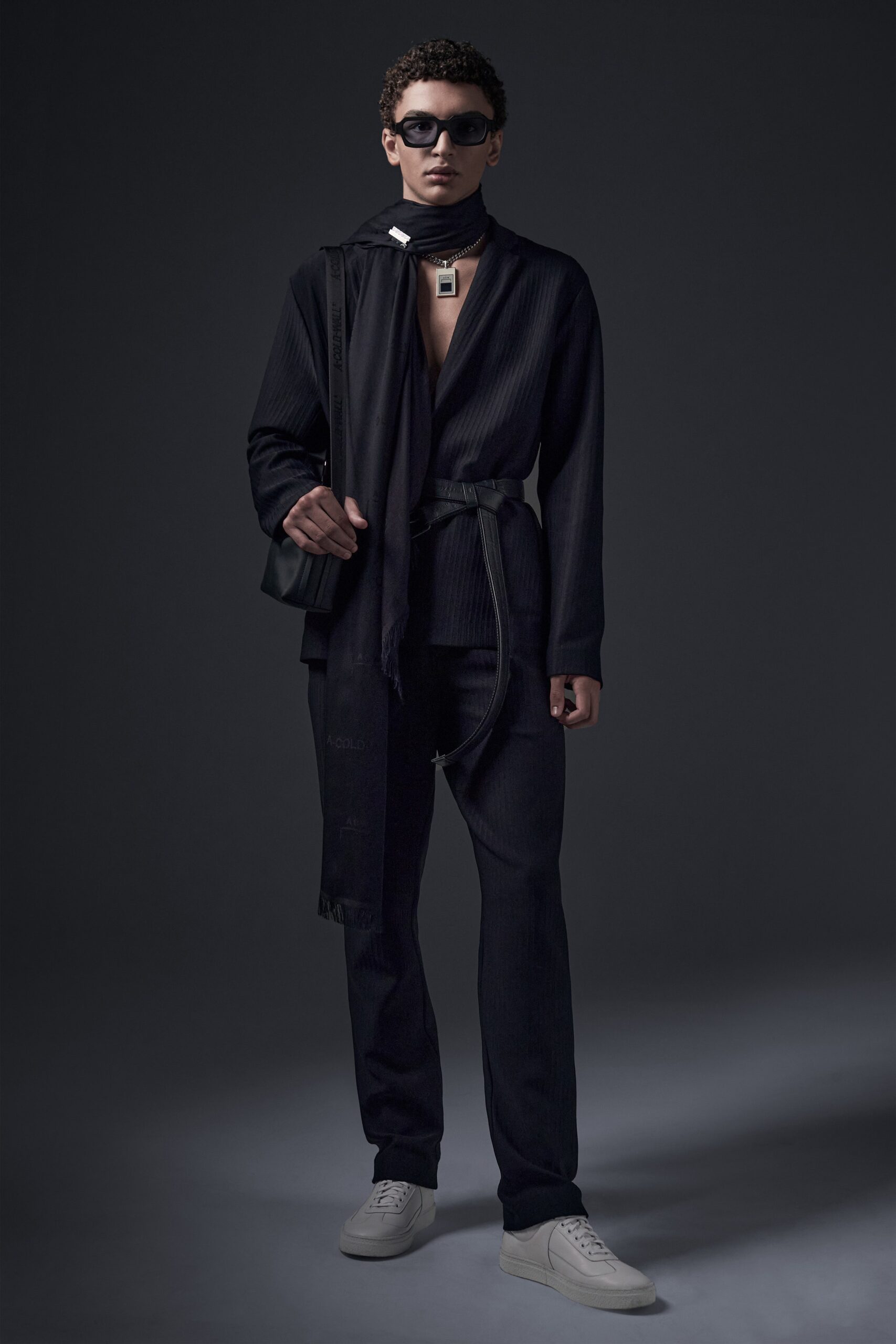 This tailored black jacket features a structured silhouette with a long-sleeve design and a collared neckline, exuding a modern sophistication. Paired with straight-leg pants, the ensemble creates a sleek and elongated profile, enhanced by subtle zippered details that add a contemporary edge.