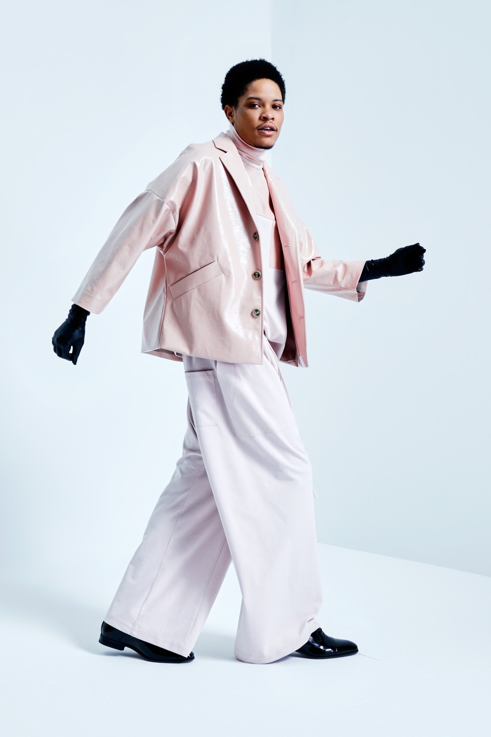 This ensemble features a relaxed-fit jacket crafted from pink leather, complemented by wide-leg pants that enhance the overall silhouette. The collared design and long sleeves add structure, while the soft hue brings a contemporary freshness to the look.