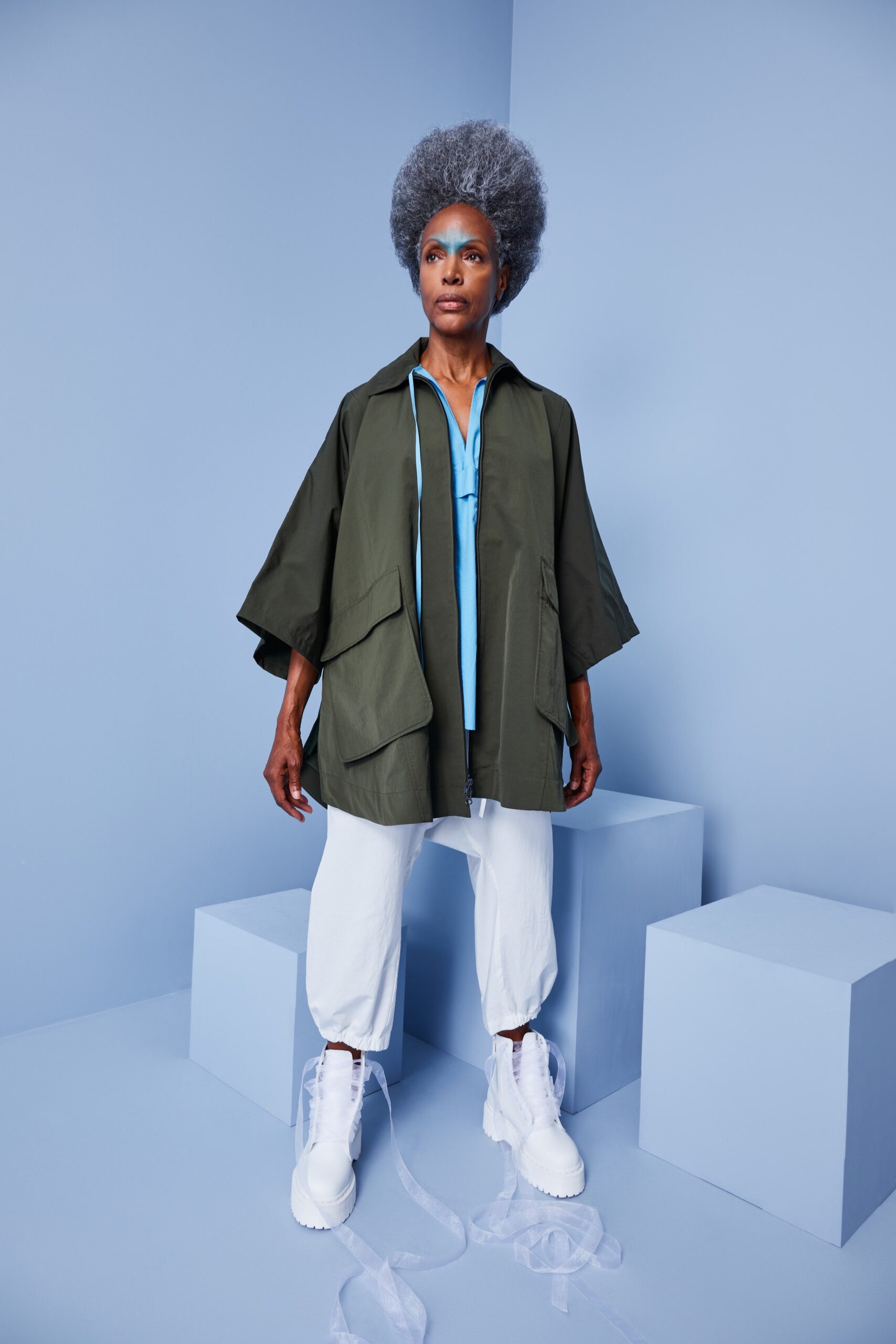 This relaxed jacket features a unique asymmetric design, complemented by a crisp collared neckline. Paired with white pants, the ensemble creates a fresh and contemporary silhouette that balances structure with ease.