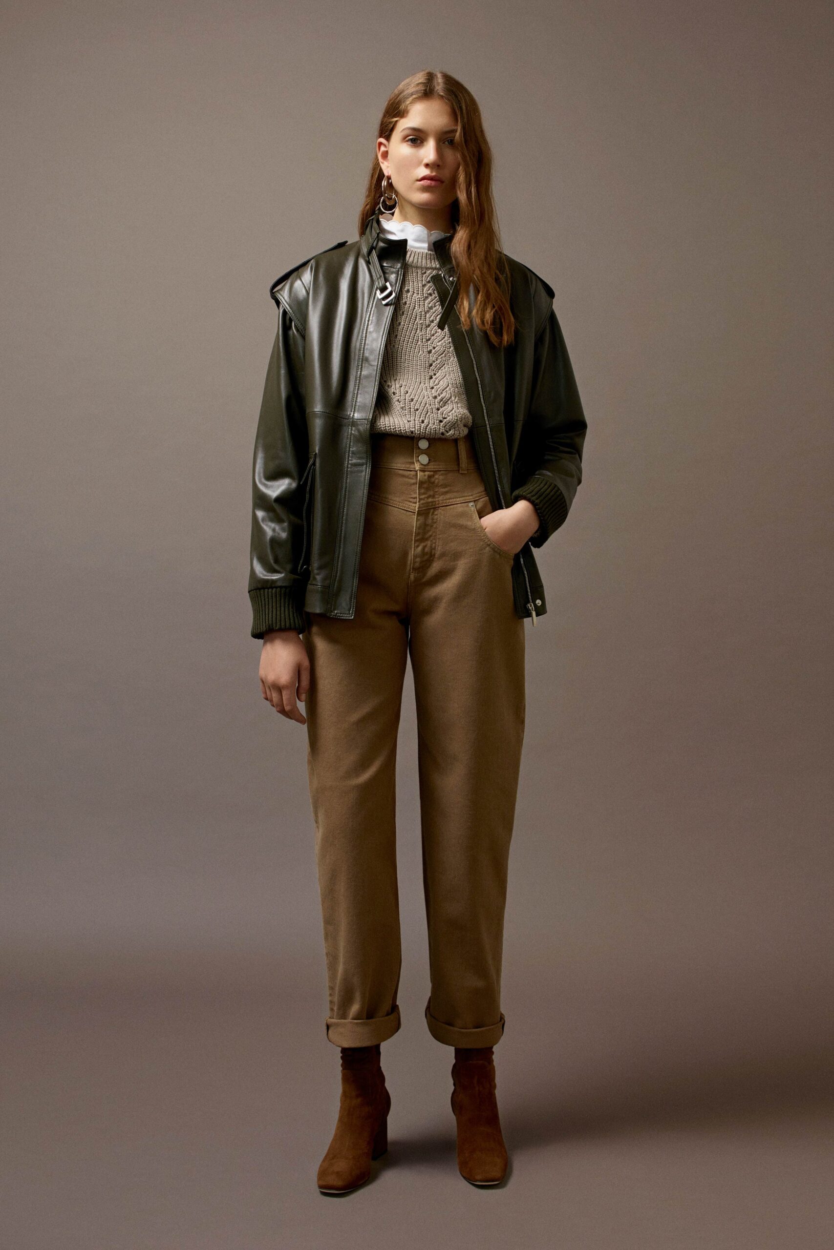 black leather jacket gray sweater beige pants