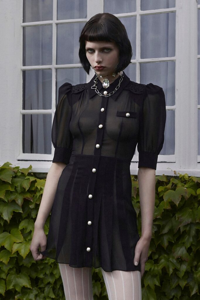 A fitted black sheer dress with short sleeves, a collared neckline, and buttoned details.