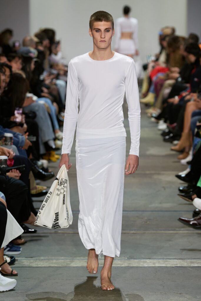 A fitted white long-sleeve dress with a high neckline and straight-leg silhouette.