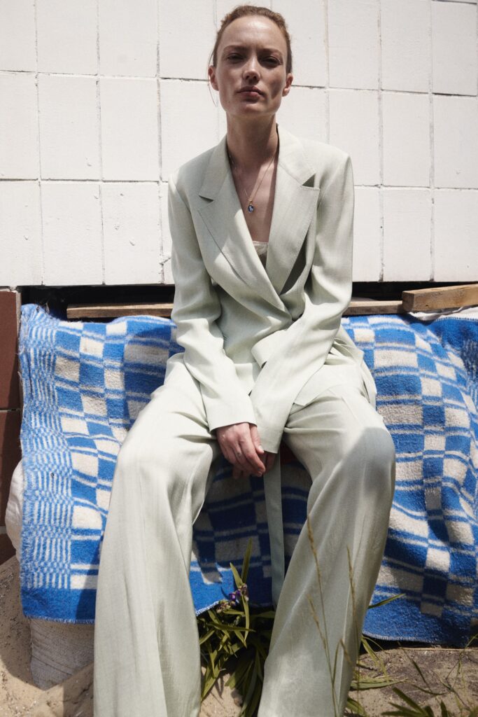 A relaxed green cotton suit featuring long sleeves and a collared design with wide-leg trousers.