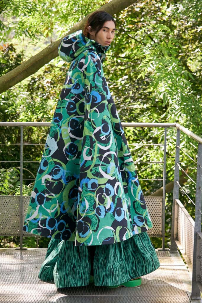 A relaxed fit printed green and blue cape dress with long sleeves and a hood.