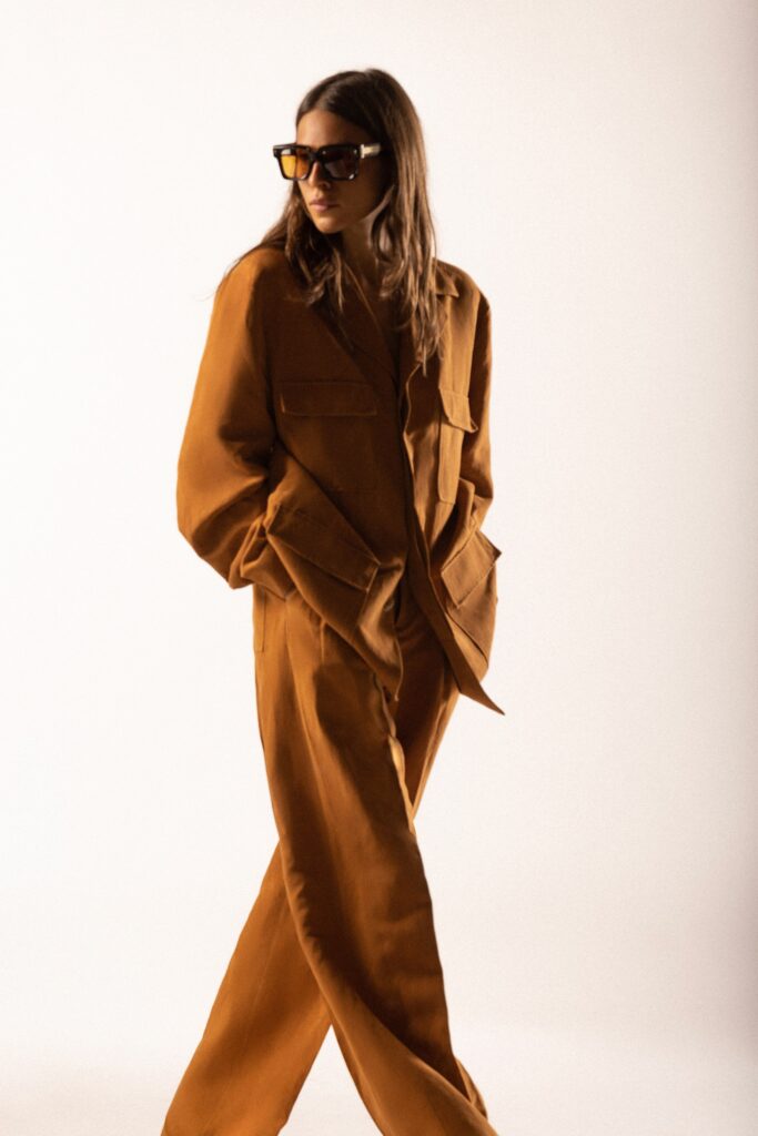 A relaxed brown cotton jacket with long sleeves and collared design, paired with matching pants.