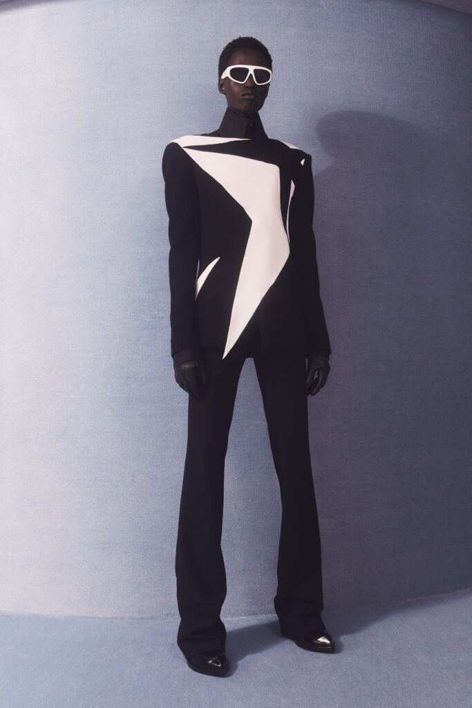 A tailored black and white asymmetric blazer paired with black pants for a striking look.