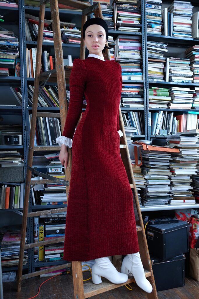 A fitted red long-sleeve dress with a high neckline and straight-leg silhouette.