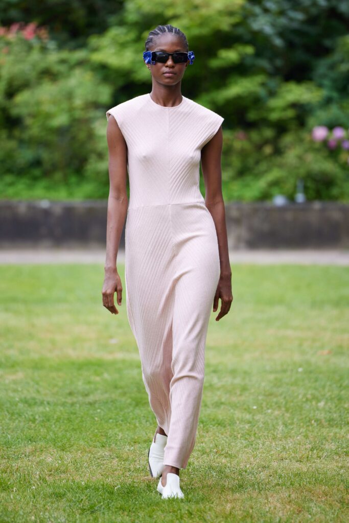 A fitted beige sleeveless jumpsuit with a sleek silhouette and modern design.