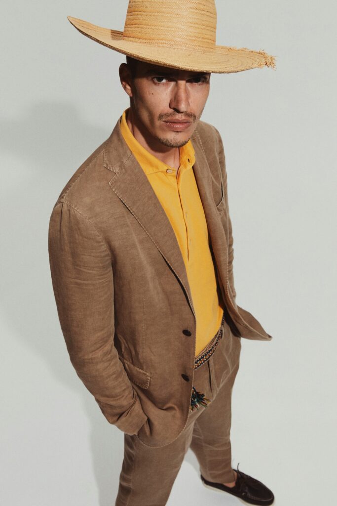 A tailored beige cotton suit with a collared long-sleeve shirt and buttoned details.