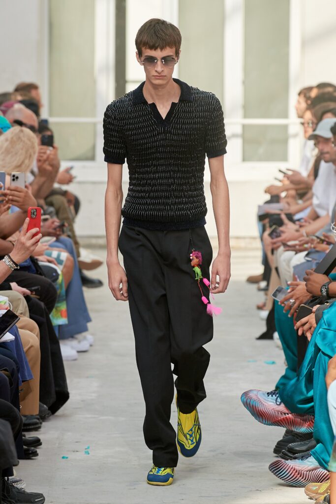 A relaxed black striped short-sleeve shirt paired with blue pants.