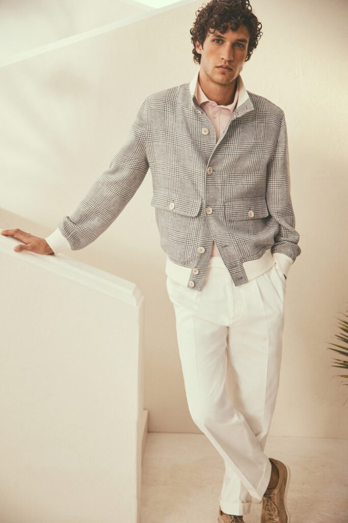 A relaxed gray checked jacket with long sleeves paired with white pants.