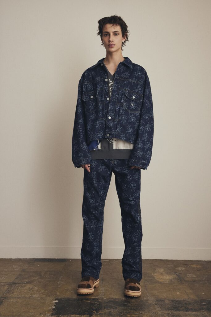 An oversized blue denim jacket with printed details paired with matching denim pants.